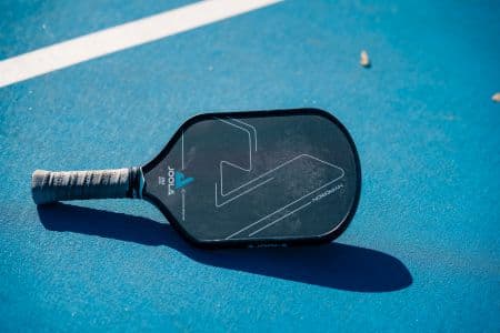 Raquette de pickleball tenue en main sur un terrain — guide d'achat Picklexpert